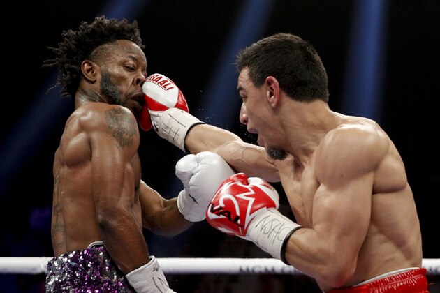 Rau'shee Warren, left, is hit by Nordine Oubaali during a WBC bantamweight championship bout Saturday, Jan. 19, 2019, in Las Vegas. (AP Photo/John Locher)