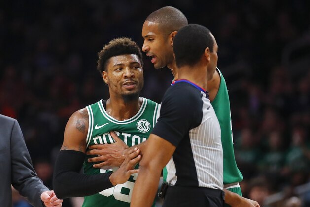 Boston Celtics guard Marcus Smart (36) is restrained by center Al Horford during the second half of the team's NBA basketball game against the Atlanta Hawks on Saturday, Jan. 19, 2019, in Atlanta. (AP Photo/Todd Kirkland)
