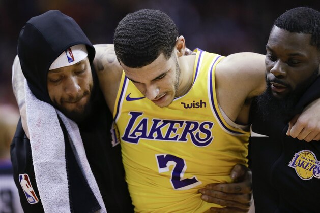 Los Angeles Lakers guard Lonzo Ball, center, is carried off the court by Michael Beasley, left, and Lance Stephenson after Ball sustained an injury during the second half of the team's NBA basketball game against the Houston Rockets, Saturday, Jan. 19, 2019, in Houston. (AP Photo/Eric Christian Smith)