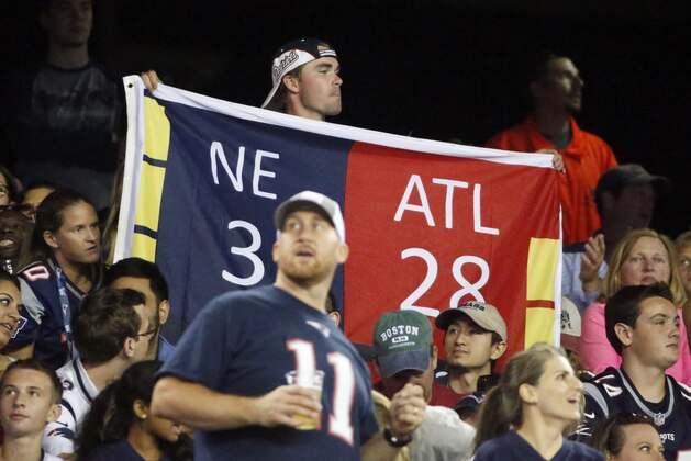Fans hold up a banner reflecting the third quarter score from the New England Patriots and Atlanta Falcons from Super Bowl LI during an NFL preseason football game against the Jacksonville Jaguars, Thursday, Aug. 10, 2017, in Foxborough, Mass. (AP Photo/Mary Schwalm)