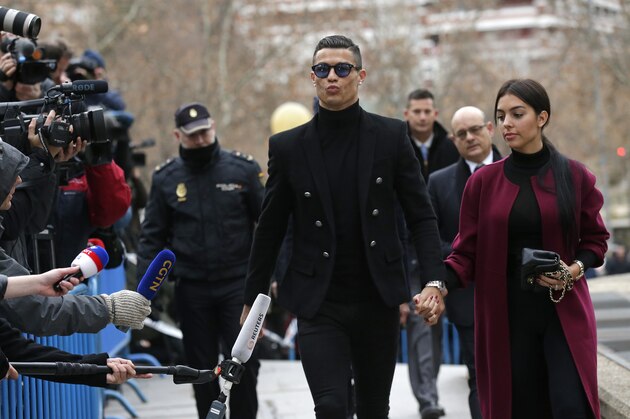 Cristiano Ronaldo arrives at the court in Madrid on Tuesday, Jan. 22, 2019. Cristiano Ronaldo is expected to plead guilty to tax fraud. The Juventus forward arrived in a black van, walked up some stairs leading to the court house and stopped to sign an autograph. The charges stem from his days at Real Madrid. (AP Photo/Manu Fernandez)
