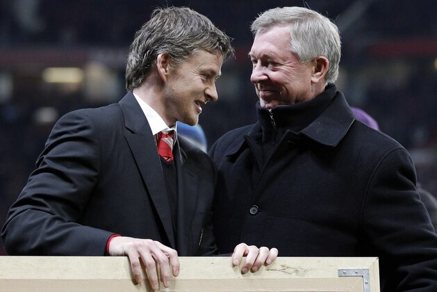 Former Manchester United player and reserve team manager Ole Gunnar Solskjaer, left, receives a gift from Manchester United manager Alex Ferguson before their English Premier League soccer match against Arsenal at Old Trafford, Manchester, England, Monday, Dec. 13, 2010. (AP Photo/Jon Super) NO INTERNET/MOBILE USAGE WITHOUT FOOTBALL ASSOCIATION PREMIER LEAGUE (FAPL) LICENCE. CALL +44 (0) 20 7864 9121 or EMAIL info@football-dataco.com FOR DETAILS