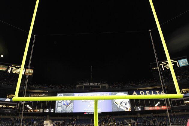 Officials guard the goalpost after fans rushed onto the field after Washington upset Stanford in an NCAA college football game, Thursday, Sept. 27, 2012, in Seattle. (AP Photo/Ted S. Warren)