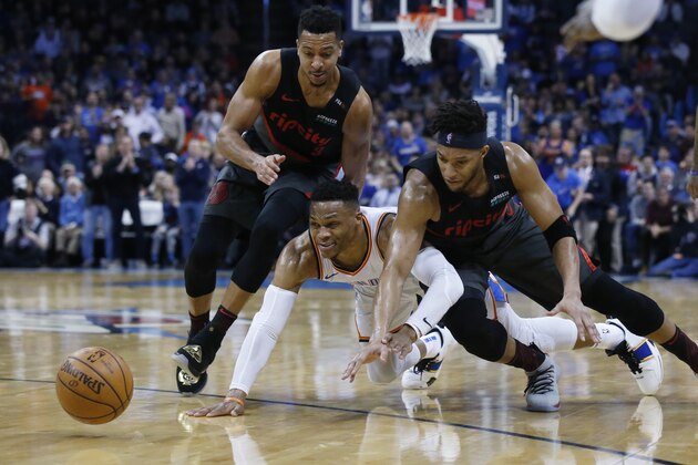 Oklahoma City Thunder guard Russell Westbrook, center, Portland Trail Blazers guard C.J. McCollum, left, and guard Evan Turner, right, chase a loose ball in the first half of an NBA basketball game in Oklahoma City, Tuesday, Jan. 22, 2019. (AP Photo/Sue Ogrocki)