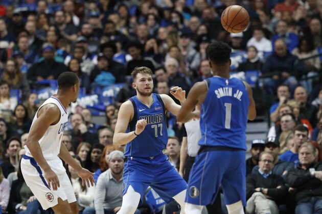 Dallas Mavericks guard Dennis Smith Jr. (1) passes to Dallas Mavericks forward Luka Doncic (77) of Germany against LA Clippers guard Avery Bradley during the first half of an NBA basketball game in Dallas, Tuesday, Jan. 22, 2019. (AP Photo/LM Otero)