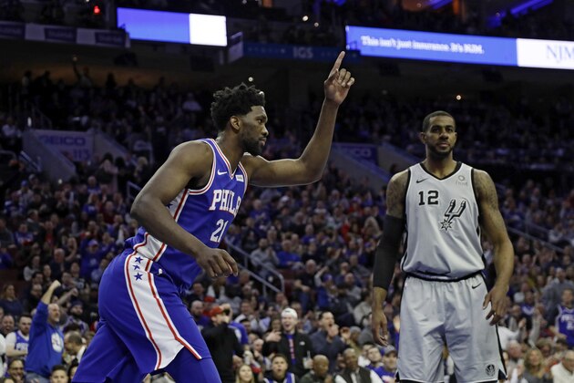 Philadelphia 76ers' Joel Embiid, left, celebrates after a dunk past San Antonio Spurs' LaMarcus Aldridge during the first half of an NBA basketball game, Wednesday, Jan. 23, 2019, in Philadelphia. (AP Photo/Matt Slocum)