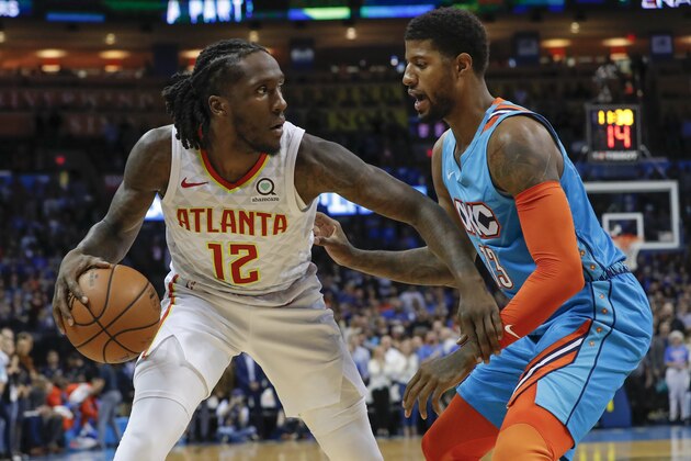 Atlanta Hawks forward Taurean Prince (12) works against Oklahoma City Thunder forward Paul George (13) during the first half of an NBA basketball game in Oklahoma City, Friday, Nov. 30, 2018. (AP Photo/Alonzo Adams)