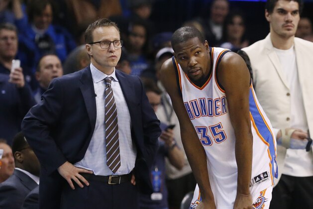 Scott Brooks, left, and forward Kevin Durant (35) talk during the fourth quarter of an NBA basketball game against the Dallas Mavericks in Oklahoma City, Thursday, Feb. 19, 2015. Oklahoma City won 104-89. (AP Photo/Sue Ogrocki)