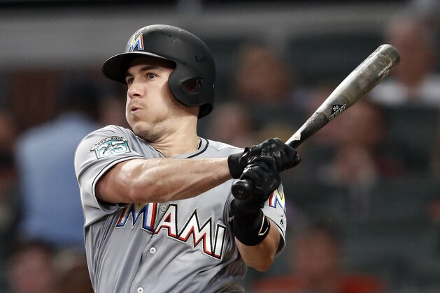 Miami Marlins' J.T. Realmuto follows through on two-run base hit in the fourth inning of a baseball game against the Atlanta Braves Tuesday, Aug. 14, 2018 in Atlanta. (AP Photo/John Bazemore)