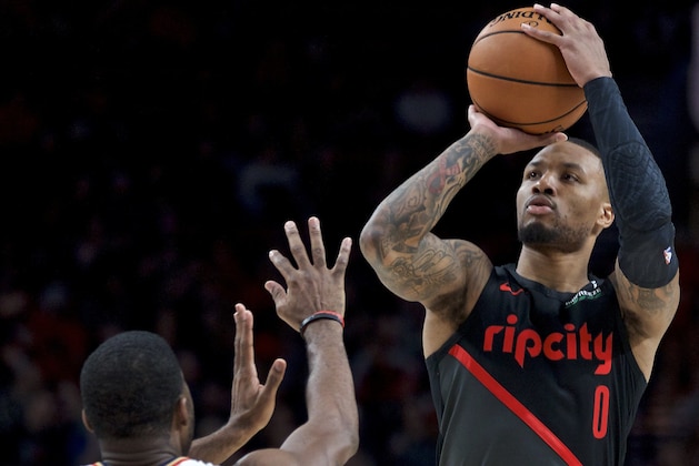 Portland Trail Blazers guard Damian Lillard, right, shoots over New Orleans Pelicans guard E'Twaun Moore during the second half of an NBA basketball game in Portland, Ore., Friday, Jan. 18, 2019. The Trail Blazers won 128-112. (AP Photo/Craig Mitchelldyer)