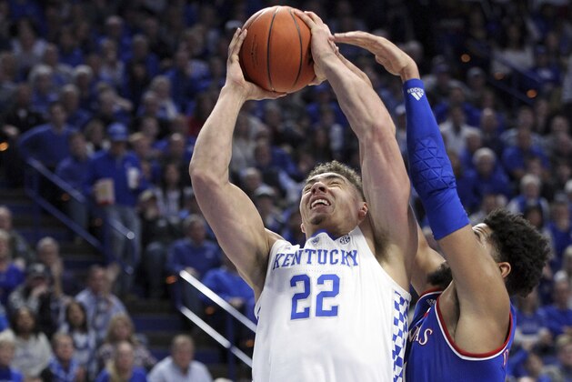 Kentucky's Reid Travis (22) shoots while pressured by Kansas' Dedric Lawson during the first half of an NCAA college basketball game in Lexington, Ky., Saturday, Jan. 26, 2019. (AP Photo/James Crisp)