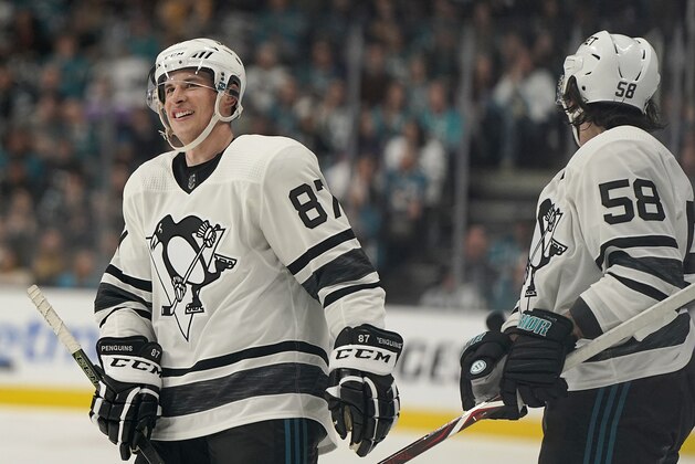 Metropolitan Division's Sidney Crosby, left, smiles next to Kris Letang, both of the Pittsburgh Penguins, during the first half of the NHL hockey All-Star Game final against the Central Division in San Jose, Calif., Saturday, Jan. 26, 2019. (AP Photo/Tony Avelar)