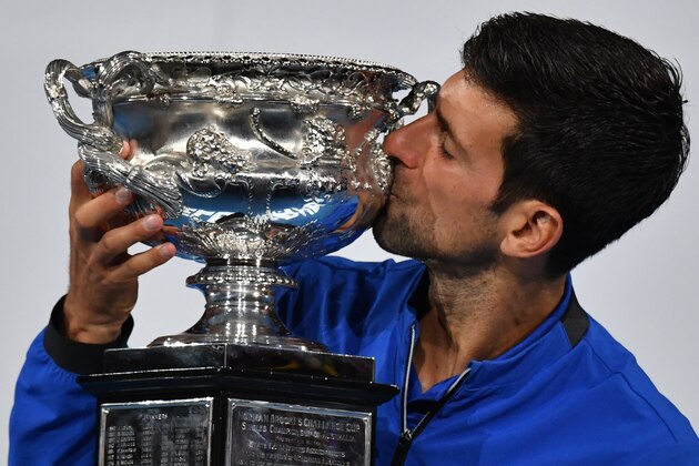 Serbia's Novak Djokovic celebrates with the championship trophy during the presentation ceremony after his victory against Spain's Rafael Nadal in the men's singles final on day 14 of the Australian Open tennis tournament in Melbourne on January 27, 2019. (Photo by Paul Crock / AFP) / -- IMAGE RESTRICTED TO EDITORIAL USE - STRICTLY NO COMMERCIAL USE --        (Photo credit should read PAUL CROCK/AFP/Getty Images)