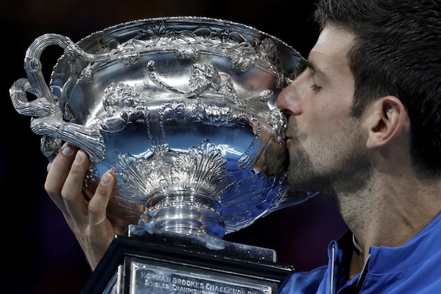 Serbia's Novak Djokovic kisses his trophy after defeating Spain's Rafael Nadal in the men's singles final at the Australian Open tennis championships in Melbourne, Australia, Sunday, Jan. 27, 2019. (AP Photo/Aaron Favila)