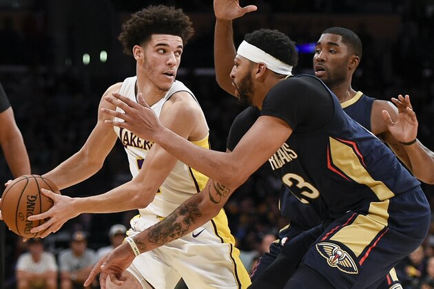 Los Angeles Lakers guard Lonzo Ball, left, holds the ball defended by New Orleans Pelicans forward Anthony Davis, front, and guard E'Twaun Moore during the second half of an NBA basketball game in Los Angeles, Sunday, Oct. 22, 2017. The Pelicans won 119-112. (AP Photo/Kelvin Kuo)