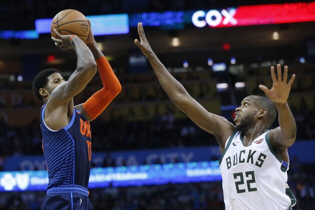 Oklahoma City Thunder forward Paul George (13) shoots over Milwaukee Bucks forward Khris Middleton (22) in the first half of an NBA basketball game in Oklahoma City, Sunday, Jan. 27, 2019. (AP Photo/Sue Ogrocki)