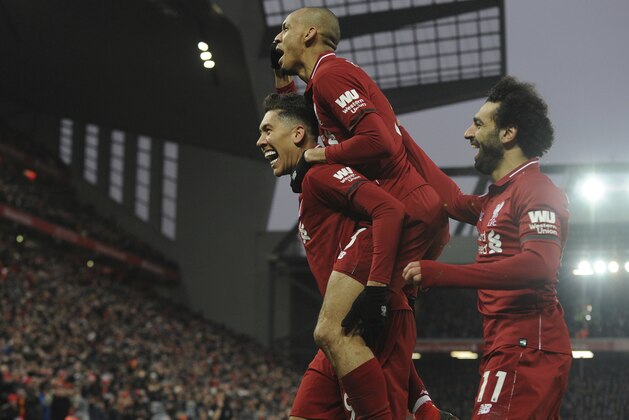 Liverpool's Roberto Firmino, left, celebrates with his teammate Liverpool's Fabinho, top, and Liverpool's Mohamed Salah, right, after scoring his side's second goal during the English Premier League soccer match between Liverpool and Crystal Palace at Anfield in Liverpool, England, Saturday, Jan. 19, 2019. (AP Photo/Rui Vieira)