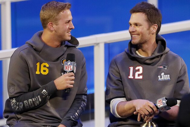 Los Angeles Rams' Jared Goff talks to New England Patriots' Tom Brady during Opening Night for the NFL Super Bowl 53 football game Monday, Jan. 28, 2019, in Atlanta. (AP Photo/John Bazemore)