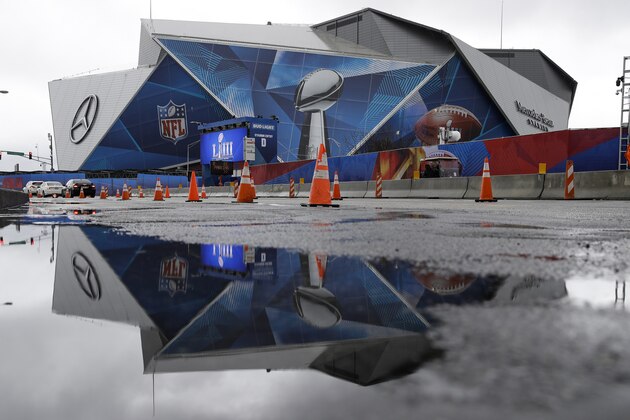 The Mercedes-Benz Stadium is reflected in a puddle from a recent rainstorm ahead of the NFL Super Bowl 53 football game, Tuesday, Jan. 29, 2019, in Atlanta. The New England Patriots face the Los Angeles Rams Sunday, Feb., 2, 2019. (AP Photo/Matt Rourke)