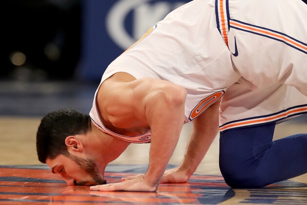 NEW YORK, NEW YORK - JANUARY 30:   Enes Kanter #00 of the New York Knicks kisses the Knicks logo on the court as he enters the game in the third quarter against the Dallas Mavericks at Madison Square Garden on January 30, 2019 in New York City.NOTE TO USER: User expressly acknowledges and agrees that, by downloading and or using this photograph, User is consenting to the terms and conditions of the Getty Images License Agreement.  (Photo by Elsa/Getty Images)