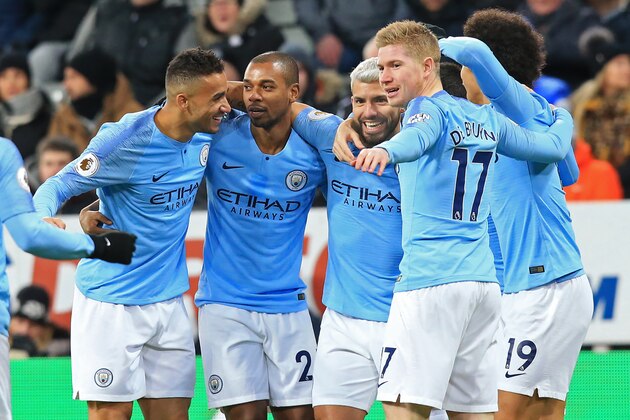 Manchester City's Argentinian striker Sergio Aguero (C) celebrates with teammates after scoring the opening goal of the English Premier League football match between Newcastle United and Manchester City at St James' Park in Newcastle-upon-Tyne, north east England on January 29, 2019. (Photo by Lindsey PARNABY / AFP) / RESTRICTED TO EDITORIAL USE. No use with unauthorized audio, video, data, fixture lists, club/league logos or 'live' services. Online in-match use limited to 120 images. An additional 40 images may be used in extra time. No video emulation. Social media in-match use limited to 120 images. An additional 40 images may be used in extra time. No use in betting publications, games or single club/league/player publications. /         (Photo credit should read LINDSEY PARNABY/AFP/Getty Images)