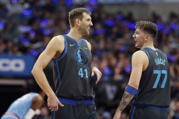 Dallas Mavericks forward Dirk Nowitzki (41), of Germany, laughs with teammate Luka Doncic (77), of Serbia, during the first half of an NBA basketball game against the Sacramento Kings in Dallas, Sunday, Dec. 16, 2018. (AP Photo/LM Otero)