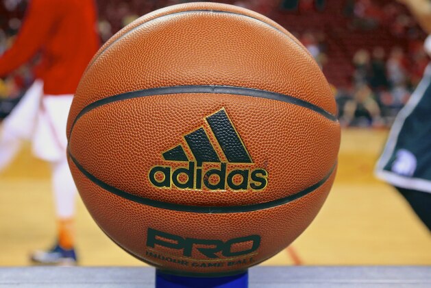 In this photo taken Jan. 24, 2015 photo, an Adidas game ball rests on the scorer's table prior to an NCAA college basketball game between Michigan State and Nebraska in Lincoln, Neb.  Unlike the NBA, which uses the Spalding ball for all games, the NCAA has no uniform brand for regular-season games. That means a team could be playing with a type of ball it’s unaccustomed to when it goes on the road.  (AP Photo/Nati Harnik)