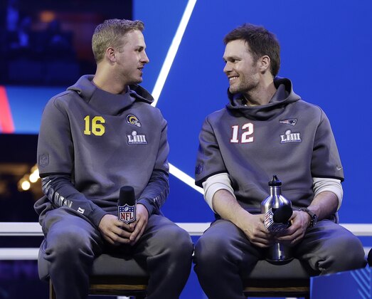 Los Angeles Rams' Jared Goff talks to New England Patriots' Tom Brady during Opening Night for the NFL Super Bowl 53 football game Monday, Jan. 28, 2019, in Atlanta. (AP Photo/Matt Rourke)