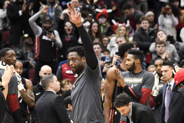 Miami Heat guard Dwyane Wade (3) gestures to the crowd after being honored during the first half of an NBA basketball game against the Chicago Bulls Saturday, Jan. 19, 2019, in Chicago. (AP Photo/David Banks)