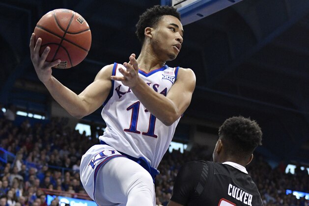 LAWRENCE, KANSAS - FEBRUARY 02:  Devon Dotson #11 of the Kansas Jayhawks passes the ball around Jarrett Culver #23 of the Texas Tech Red Raiders in the first half at Allen Fieldhouse on February 02, 2019 in Lawrence, Kansas. (Photo by Ed Zurga/Getty Images)