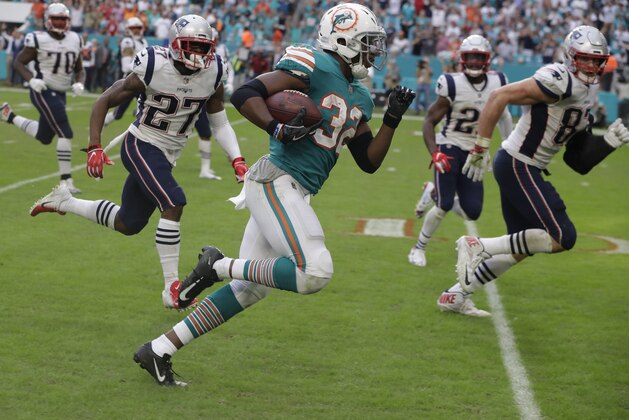 Miami Dolphins running back Kenyan Drake (32) runs for a touchdown during the second half of an NFL football game against the New England Patriots, Sunday, Dec. 9, 2018, in Miami Gardens, Fla. The Dolphins defeated the Patriots 34-33. (AP Photo/Lynne Sladky)