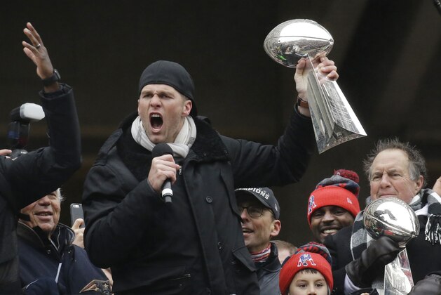 New England Patriots quarterback Tom Brady holds a Super Bowl trophy while addressing the crowd along with head coach Bill Belichick, right, during a rally Tuesday, Feb. 7, 2017, in Boston, to celebrate Sunday's 34-28 win over the Atlanta Falcons in the NFL Super Bowl 51 football game in Houston. (AP Photo/Elise Amendola)