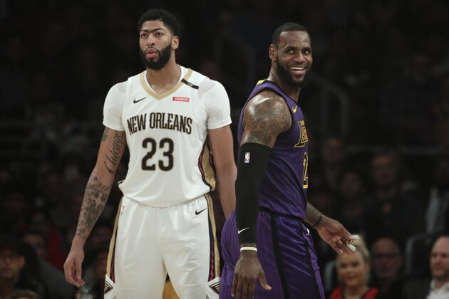 Los Angeles Lakers' LeBron James, right, smiles as he walks past New Orleans Pelicans' Anthony Davis during the first half of an NBA basketball game Friday, Dec. 21, 2018, in Los Angeles. (AP Photo/Jae C. Hong)