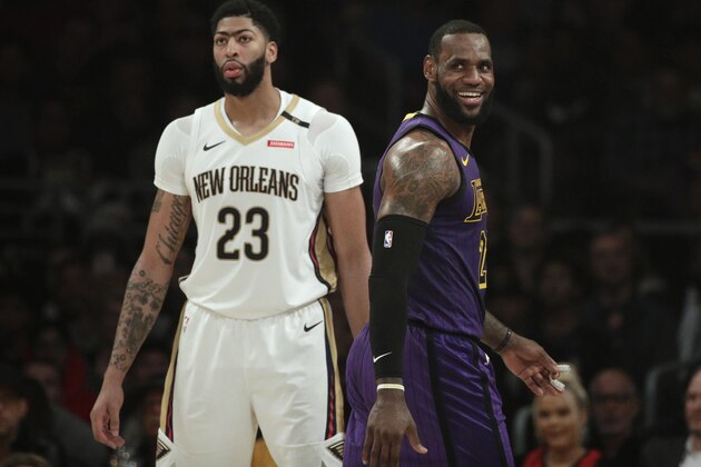 Los Angeles Lakers' LeBron James, right, smiles as he walks past New Orleans Pelicans' Anthony Davis during the first half of an NBA basketball game Friday, Dec. 21, 2018, in Los Angeles. (AP Photo/Jae C. Hong)