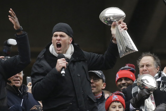 New England Patriots quarterback Tom Brady holds a Super Bowl trophy while addressing the crowd along with head coach Bill Belichick, right, during a rally Tuesday, Feb. 7, 2017, in Boston, to celebrate Sunday's 34-28 win over the Atlanta Falcons in the NFL Super Bowl 51 football game in Houston. (AP Photo/Elise Amendola)