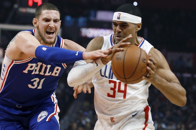 Philadelphia 76ers forward Mike Muscala, left, fouls Los Angeles Clippers forward Tobias Harris during the first half of an NBA basketball game in Los Angeles, Tuesday, Jan. 1, 2019. (AP Photo/Alex Gallardo)
