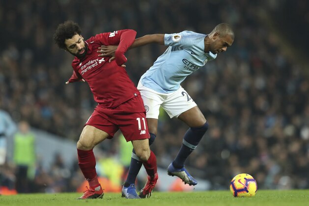 Liverpool's Mohamed Salah, left vies for the ball with Manchester City's Fernandinho during their English Premier League soccer match between Manchester City and Liverpool at the Ethiad stadium, Manchester England, Thursday, Jan. 3, 2019. (AP Photo/Jon Super)
