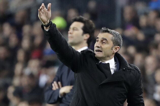 Barcelona coach Ernesto Valverde, front, gives directions as Real coach Santiago Solari, rear, watches his players during the Copa del Rey semifinal first leg soccer match between FC Barcelona and Real Madrid at the Camp Nou stadium in Barcelona, Spain, Wednesday Feb. 6, 2019. (AP Photo/Emilio Morenatti)