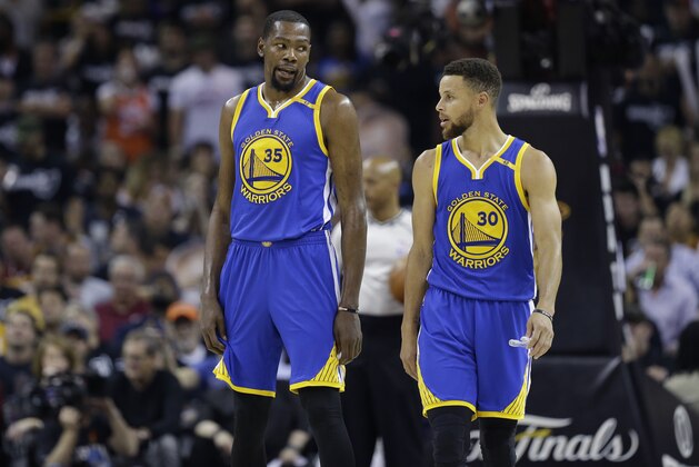 Golden State Warriors forward Kevin Durant (35) and Stephen Curry (30) talk during the first half against the Cleveland Cavaliers in Game 4 of basketball's NBA Finals in Cleveland, Friday, June 9, 2017. (AP Photo/Tony Dejak)