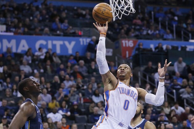 Oklahoma City Thunder guard Russell Westbrook (0) shoots between Memphis Grizzlies forward Jaren Jackson Jr., left, and guard Jevon Carter, rear, during the second half of an NBA basketball game in Oklahoma City, Thursday, Feb. 7, 2019. (AP Photo/Sue Ogrocki)