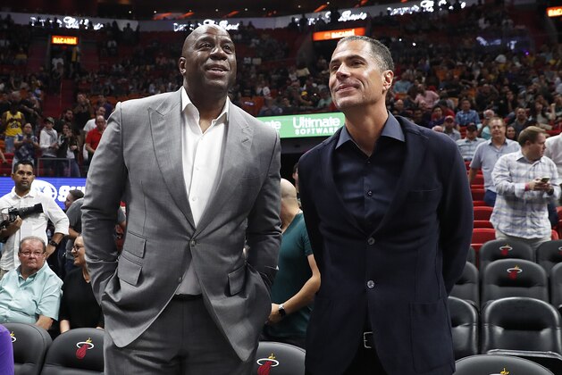 Los Angeles Lakers general manager Rob Pelinka, right, speaks with Lakers president of basketball operations Magic Johnson, left, before before an NBA basketball game against the Miami Heat Sunday, Nov. 18, 2018, in Miami, Fla. (AP Photo/Brynn Anderson)