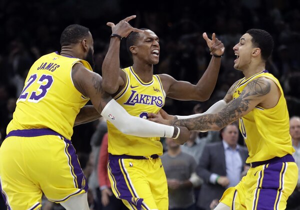 Los Angeles Lakers guard Rajon Rondo, middle, celebrates his game-winning shot with teammates LeBron James (23) and Kyle Kuzma (0), in an NBA basketball game against the Boston Celtics, Thursday, Feb. 7, 2019, in Boston. The Lakers won 129-128. (AP Photo/Elise Amendola)