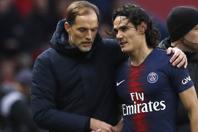 SG coach Thomas Tuchel, left, speaks with PSG's Edinson Cavani as he leaves the pitch during the French League One soccer match between Paris Saint-Germain and Bordeaux at the Parc des Princes stadium in Paris, Saturday, Feb. 9, 2019. (AP Photo/Christophe Ena)