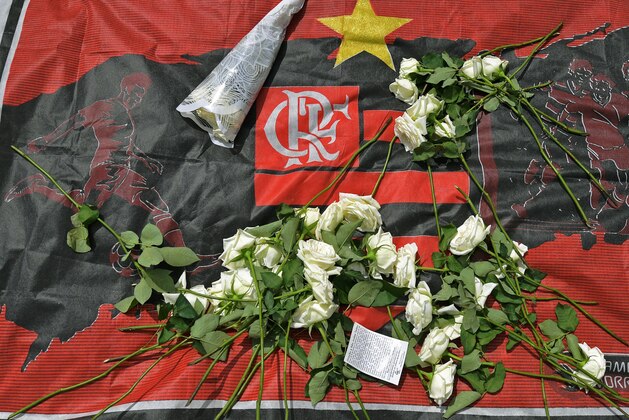 Flowers are seen on a flag of Brazilian football club Flamengo at the entrance of its  training center, in Rio de Janeiro, Brazil on February 8, 2019, after a deadly fire. - Fire swept through a training facility for Brazil's most popular football club Flamengo Friday, killing at least 10 people, authorities said. (Photo by CARL DE SOUZA / AFP)        (Photo credit should read CARL DE SOUZA/AFP/Getty Images)