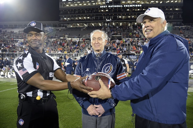 Official Ron Turner (82) and Orlando Apollos vice president of player personnel Bill Kuharich, right, pose with Apollo VII astronaut Walter Cunningham before an Alliance of American Football game between the Apollos and the Atlanta Legends on Saturday, Feb. 9, 2019, in Orlando, Fla. (AP Photo/Phelan M. Ebenhack)