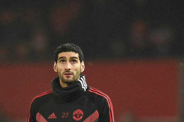 (FILES) This file photo taken on  December 5, 2018 shows Manchester United's Belgian midfielder Marouane Fellaini warming up for the English Premier League football match between Manchester United and Arsenal at Old Trafford in Manchester, north west England. - Marouane Fellaini should brace for a culture shock at Chinese club Shandong Luneng following his move from Premier League Manchester United.The 31-year-old -- known as 'Fluffy Head' in China, although he now has short hair -- on February 1, 2019 became the latest player to swap Europe for the Chinese Super League on big money. (Photo by OLI SCARFF / AFP)        (Photo credit should read OLI SCARFF/AFP/Getty Images)