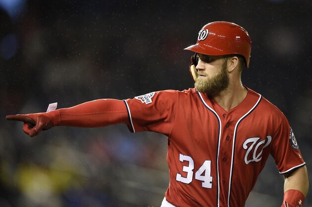 FILE - In this Sept. 8, 2018, file photo, Washington Nationals' Bryce Harper pointing to the dugout after he hit a two-run home run during the seventh inning of the second baseball game of a doubleheader against the Chicago Cubs, in Washington.  As the start of spring training approaches, the Washington Nationals are waiting right along with the rest of the world to find out where Harper will be playing next season.  (AP Photo/Nick Wass, File)