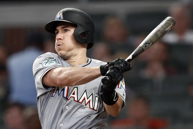 FILE - In this Tuesday, Aug. 14, 2018 file photo, Miami Marlins' J.T. Realmuto follows through on two-run base hit in the fourth inning of a baseball game against the Atlanta Braves in Atlanta. A person familiar with the negotiations says Miami Marlins All-Star catcher J.T. Realmuto has been traded to the Philadelphia Phillies for catcher Jorge Alfaro, two pitching prospects and international bonus pool allocation. The person confirmed the trade to The Associated Press on condition of anonymity Thursday, Feb. 7, 2019 because the teams had not announced it. (AP Photo/John Bazemore, File)