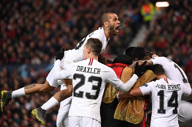 Paris Saint-Germain's Brazilian defender Dani Alves (top) reacts as Paris Saint-Germain's French striker Kylian Mbappe is mobbed after scoring his team's second goal during the first leg of the UEFA Champions League round of 16 football match between Manchester United and Paris Saint-Germain (PSG) at Old Trafford in Manchester, north-west England on February 12, 2019. (Photo by FRANCK FIFE / AFP)        (Photo credit should read FRANCK FIFE/AFP/Getty Images)