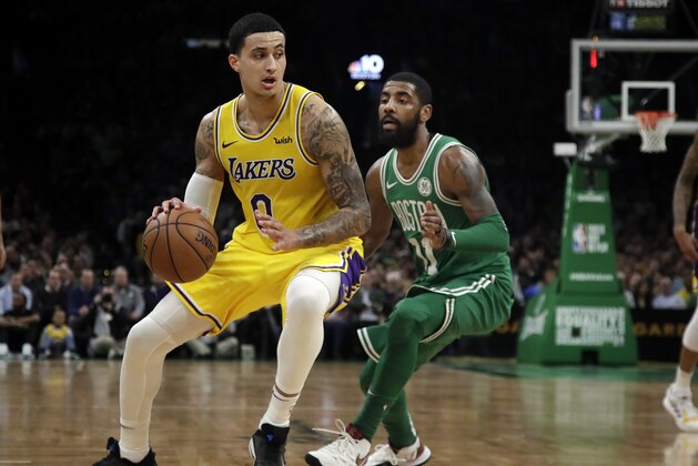 In this Feb. 7, 2019 photo, Los Angeles Lakers forward Kyle Kuzma (0) drives against Boston Celtics guard Kyrie Irving during an NBA basketball game in Boston. Kuzma is wearing Nike's latest performance basketball shoes, which from concept to reality, took about three years to put together. Or 30 years, depending on how you count. The Nike Adapt BB _ a self-lacing smart shoe that can be controlled by a smartphone _ gets released to the public on Sunday, Feb. 17, 2019, a date that just happens to coincide with the NBA All-Star Game in Charlotte. It has a motor embedded within the shoe, and a hefty $350 price tag. It has a motor embedded within the shoe, and a hefty $350 price tag. (AP Photo/Elise Amendola)
